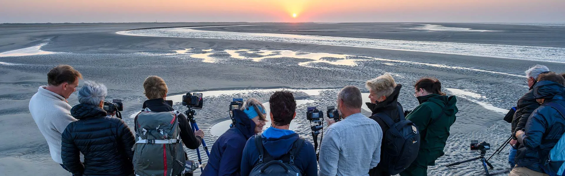 Fotografen met zonsondergang op het strand.